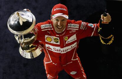 Sebastian Vettel muestra su trofeo a los fotógrafos.