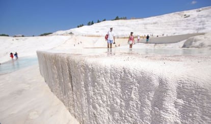 Paredes de caliza con forma de catarata de espuma blanca petrificada en Pamukkale, en Turquía.