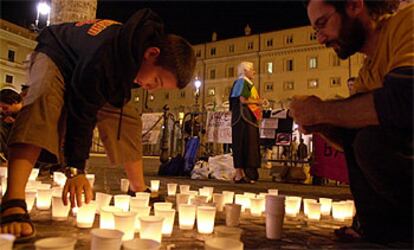 Varias personas encienden velas frente a la sede del Gobierno en Roma para pedir la libertad de Torretta y Pari.