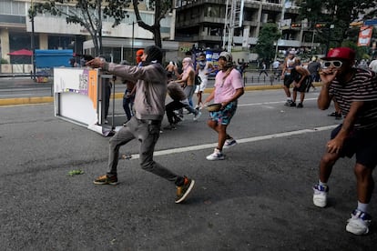 Un manifestante apunta con un arma durante enfrentamientos con la policía en medio de las manifestaciones del lunes 29 de julio de 2024.