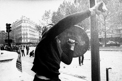 Un manifestante tira piedras a la policía en una calle de París durante las protestas de Mayo de 1968.