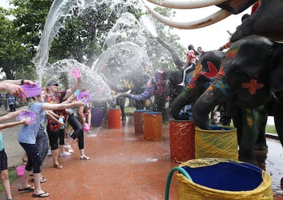 Elefantes y un grupo de turistas se lanzan agua durante los preparativos del Songkran, la festividad que señala el fin de la época seca y que precede a las lluvias del monzón, en Ayutthaya (Tailandia).