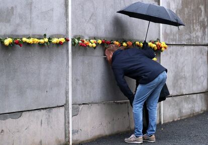 Um homem olha através de um buraco no Memorial do Muro, durante as comemorações em Berlim.