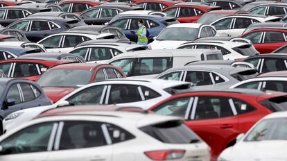 Una trabajadora de Ford camina, en mayo del año pasado, entre automóviles aparcados en el exterior de la planta en Almussafes (Valencia), listos para ser enviados a los concesionarios.