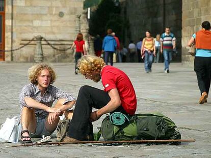 Dos peregrinos descansan en la Plaza del Obradoiro.