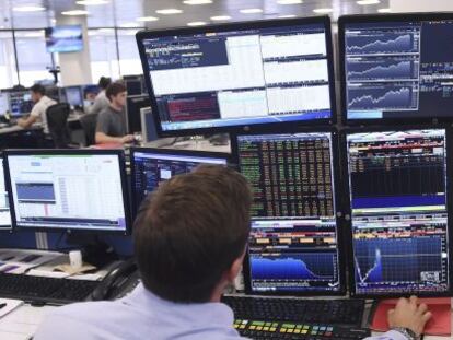 Un inversor frente a pantallas de Bloomberg en Londres