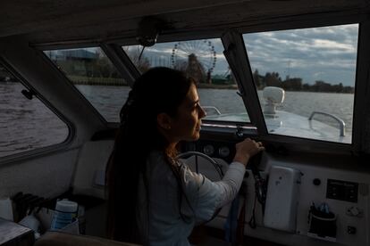 Leila Peluso maneja su embarcación sobre un río de Tigre, en la provincia de Buenos Aires.