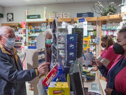 Clientes de una farmacia compran mascarillas en Soto del Real (Madrid).