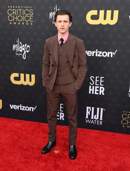 Tom Holland acudió sin Zendaya y aportó un punto de color a su estilismo distanciándose del negro predominante en los estilismos masculinos con este traje marrón con camisa rosa de Prada.