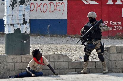 Un agente de policía haitiano apunta a un manifestante con un arma, en las proximdades del Aeropuerto Internacional, en Puerto Príncipe, el 15 de febrero, durante el noveno día de protestas. 