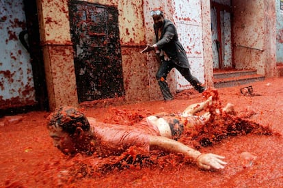 Un hombre se desliza por el suelo lleno de tomate durante la fiesta de la Tomatina.