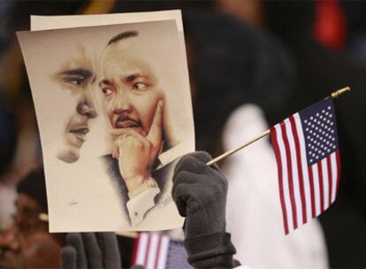 Un partidario de Obama enarbola una bandera y un cartel con los rostros de su candidato y del líder histórico de los derechos civiles Martin Luther King, asesinado en 1968.