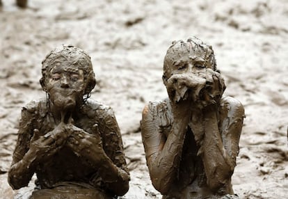 Dos niños juegan en una piscina de barro durante el Día del Barro del Condado de Wayne, en el parque Nankin Mills en Westland, Michigan (EE UU).