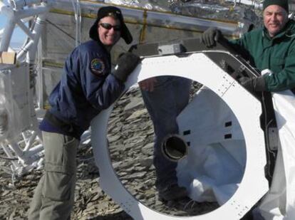 Integrantes de la expedición para la recuperación del experimento 'Sunrise' muestran el espejo primario del telescopio, intacto. El instrumento español IMaX se distingue parcialmente a la izquierda, cubierto por un plástico transparente.