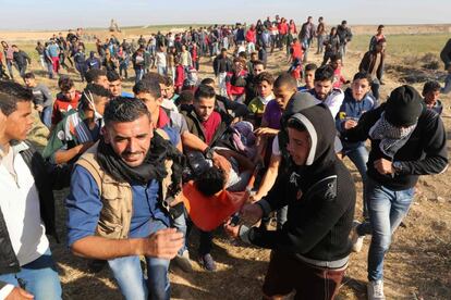 Varios manifestantes llevan a un herido de bala durante la manifestación junto al límite de Gaza.
