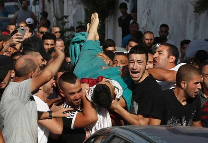Varios hombres llevan el cuerpo de un hombre muerto por un disparo durante los disturbios en Jerusalén Este.