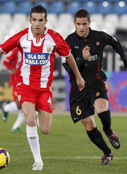 El jugador del Almería Julio Alvarez protege el balón ante Mario Suárez, del Mallorca