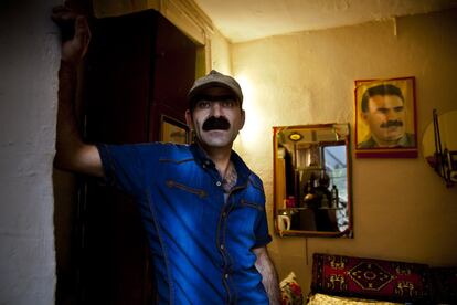 Mehmet, kurdo de 40 años, posa en la puerta de su casa. El salón de su vivienda lo preside un retrato del presidente del PKK (Partido de los trabajadores del Kurdistán), Abdulá Ocalam.