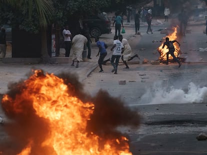 Manifestantes corren en una calle de Dakar mientras la policía les lanza gases lacrimógenos, este jueves 1 de junio.