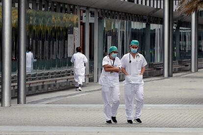 Personal sanitario descansa en los exteriores del hospital de campaña instalado en Ifema, este viernes en Madrid.