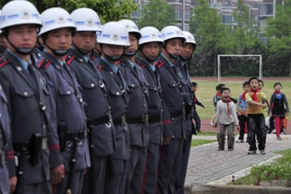 Un grupo de guardias permanece en formación ante una escuela primaria en la provincia china de Jiangsu.