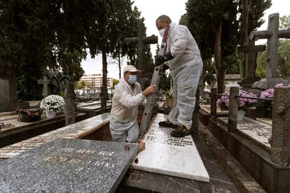 Dos trabajadores reparan una de las tumbas en el cementerio de La Salud de la capital cordobesa, este lunes.
