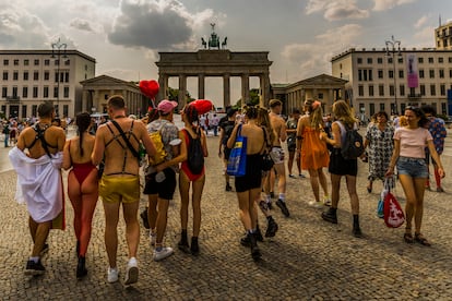 Un grupo de gente pasea por la puerta de Brandemburgo al finalizar el desfile del día del orgullo LGBT en Berlín.