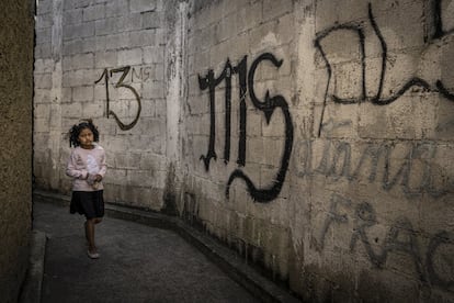 Una niña atraviesa un callejón de Ciudad de Guatemala marcado con pintadas de la Mara Salvatrucha, la pandilla más poderosa del país junto a su mayor rival, el Barrio 18.