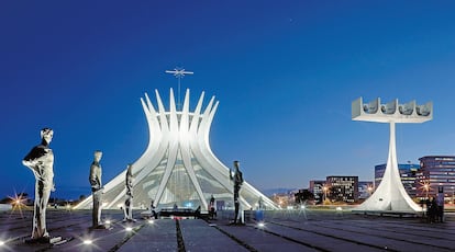 A la catedral metropolitana se entra descendiendo, como quien baja al infierno para llegar a un cielo de luz y cristales azules en el que flotan los ángeles. Estatuas de los arcángeles de cuatro metros de altura marcan el acceso al edificio.