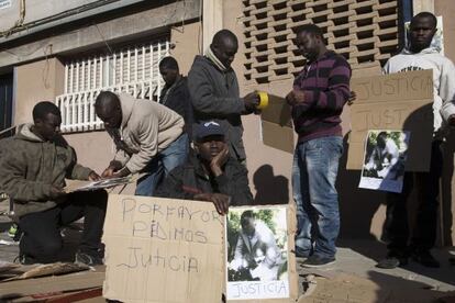 Un grupo de senegaleses en el lugar donde un compatriota fue asesinado a tiros.