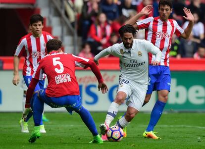 Isco (centro) controla el balón presionado por los jugadores del Sporting.