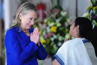 Clinton responde al saludo tradicional durante la visita a su homólogo en India.