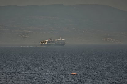 Un grupo de refugiados cruza en una barca de plástico los 10 kilómetros de mar entre la costa turca (al fondo de la imagen) y la isla de Lesbos (Grecia). Las mafias cobran alrededor de 1.000 euros a cada uno de los pasajeros de ese bote. El precio de un billete por cruzar legalmente en ferry son unos 10 euros.