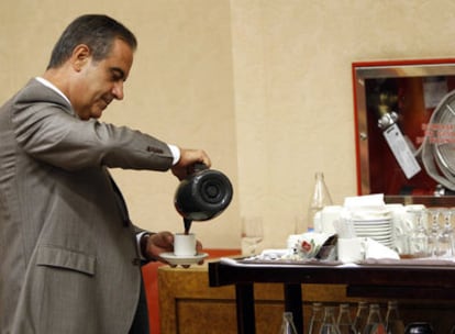 Celestino Corbacho se sirve un café antes de comenzar su comparecencia parlamentaria.