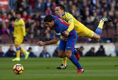 El jugador del Barcelona Luis Suárez (i) es bloqueado por Roque Mesa, de Las Palmas.