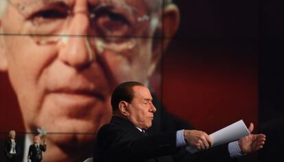 Berlusconi participa en un programa de la televisión pública italiana. Detrás, una imagen de Mario Monti.