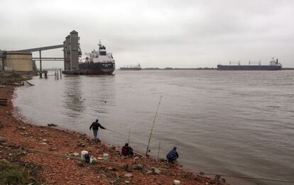 Rosario: Al fondo, los barcos cargan cereales; abajo, pescadores pobres.