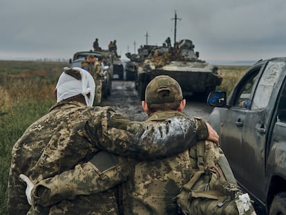 A Ukrainian soldier helps a wounded fellow soldier on the road in the freed territory in the Kharkiv region, Ukraine, Monday, Sept. 12, 2022. Ukrainian troops retook a wide swath of territory from Russia on Monday, pushing all the way back to the northeastern border in some places, and claimed to have captured many Russian soldiers as part of a lightning advance that forced Moscow to make a hasty retreat. (AP Photo/Kostiantyn Liberov)