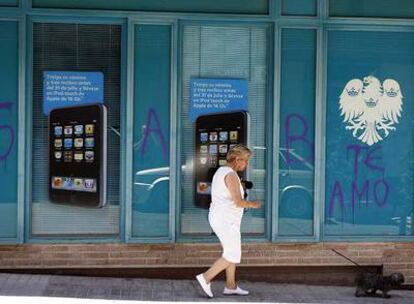 Una mujer pasa ante una sucursal bancaria próxima al domicilio de la víctima, donde según la familia el supuesto agresor hizo esa pintada.
Gabriela Toledo y René Andia Rosado.