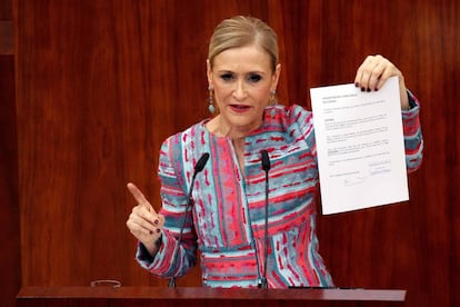 Madrid premier Cristina Cifuentes shows a document to prove that she obtained her degree lawfully.