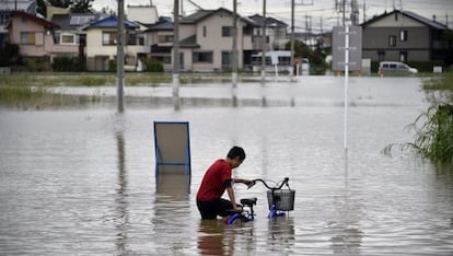 Un niño circula con sus bicicletas por una calle inundada en Tokio, el 10 de septiembre de 2015.