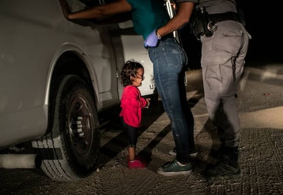 Yana, una niña de Honduras, llora mientras su madre, Sandra Sánchez, es cacheada por un policía de fronteras en el Estado de Texas.