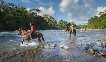 Dos jinetes cruzan el río Sarapiquí, en la provincia de Heredia (Costa Rica). 