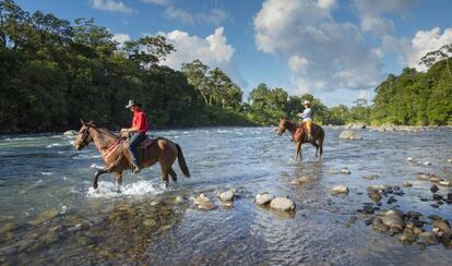 Dos jinetes cruzan el río Sarapiquí, en la provincia de Heredia (Costa Rica). 