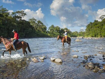 Dos jinetes cruzan el río Sarapiquí, en la provincia de Heredia (Costa Rica). 