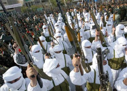 Policías iraquíes y <b><i>kamikazes</b></i> levantan sus armas durante una marcha en apoyo a Sadam Husein ayer en Bagdad.