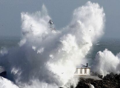 El fuerte oleaje llegó a ocultar en algunos momentos casi todo el faro de la isla de Mouro, en la bocana del puerto de Santander.