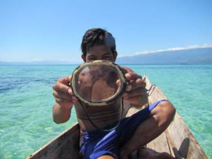 Un buceador bajau muestra sus 'gafas de bucear' hechas de madera.