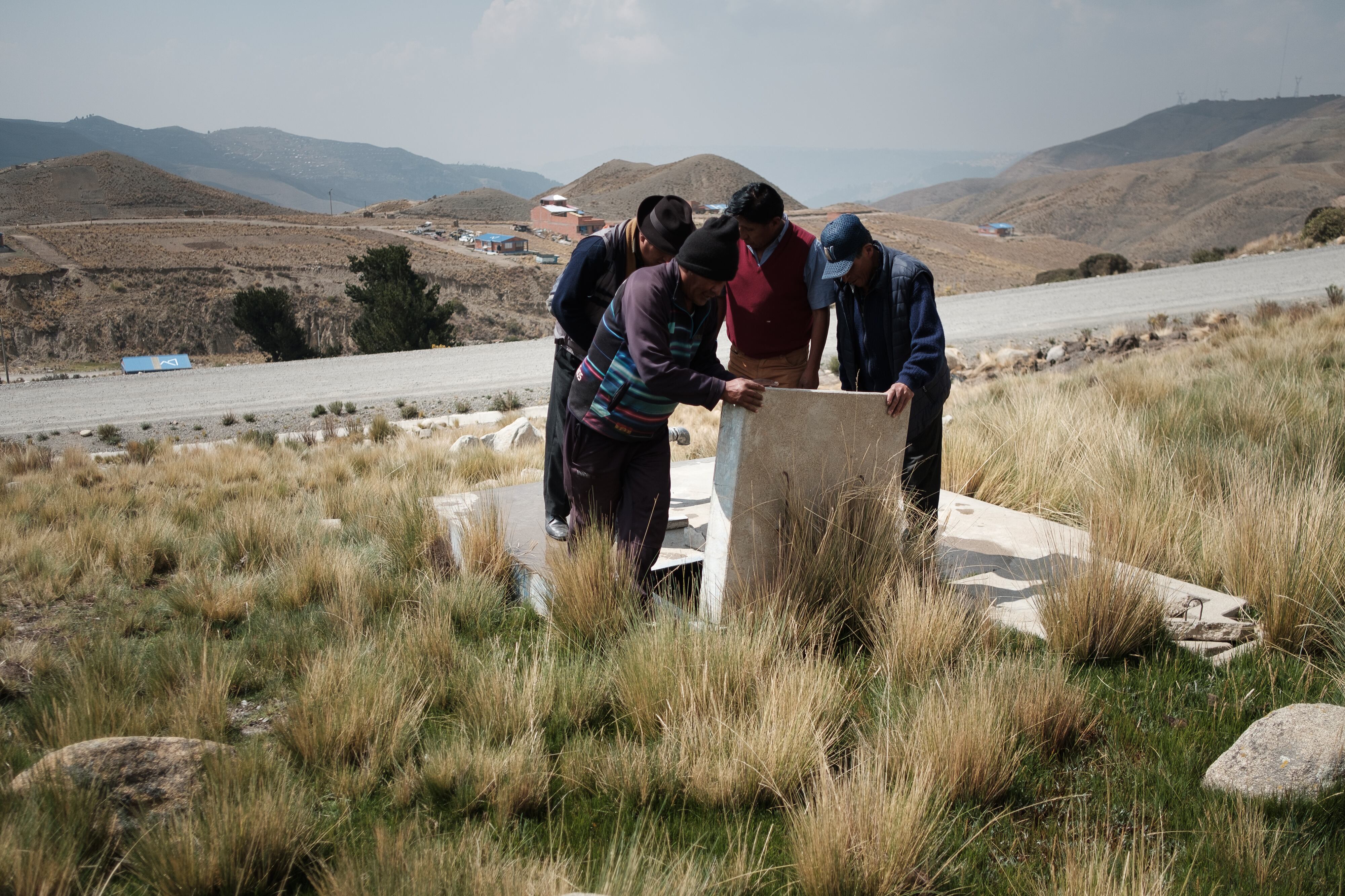 Pobladores de la comunidad Siete Lagunas observan el bajo nivel de agua de uno de sus depósitos.