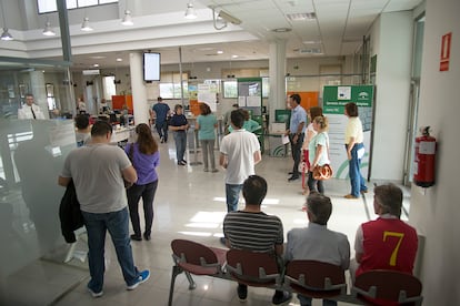 Varias personas esperan su turno en una oficina de empleo en la localidad sevillana de Sanlúcar la Mayor.